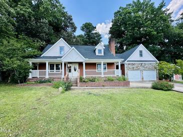 Charming home with a brick foundation, front porch, and an attached two-car garage at 101 Creekside Dr, Selma, NC 27576