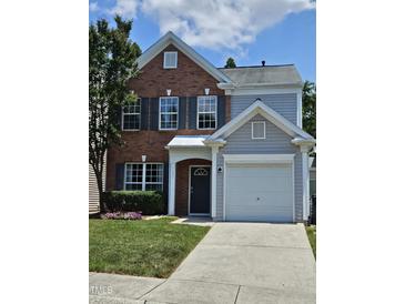 Two-story home featuring a combination of brick and gray siding and an attached garage at 121 Brentfield Loop, Morrisville, NC 27560