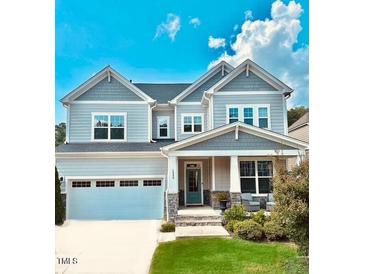 Beautiful two-story home with manicured lawn, attached garage and inviting front porch at 1880 Woodall Crest Dr, Apex, NC 27502