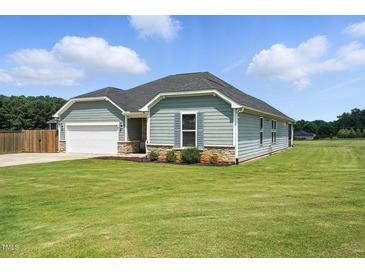 Charming single-story home with light blue siding, stone accents, and a well-manicured lawn at 25 Harlow Ct, Fuquay Varina, NC 27526