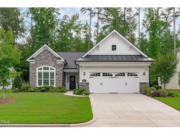 Charming home featuring a stone and white exterior, well-manicured lawn, and a two-car garage at 2511 Range Overlook Xing, Apex, NC 27523