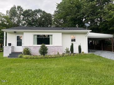 Charming single-story home with a white exterior, brick accents, and a well-manicured front lawn at 331 E Lillington St, Angier, NC 27501