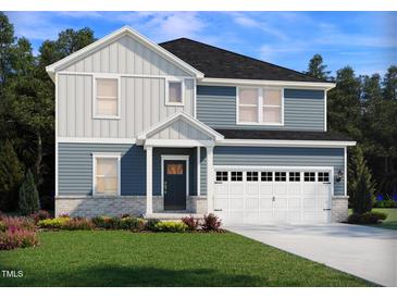 Charming two-story home featuring a two-car garage, well-manicured lawn, and welcoming front porch at 3813 Rosebush Dr, Zebulon, NC 27597
