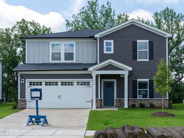 Charming two-story home with a well-manicured lawn, attached garage, and neutral-toned siding at 3845 Rosebush Dr, Zebulon, NC 27597