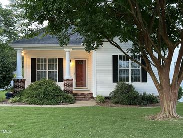 Charming single-story home featuring a cozy front porch, a well-manicured lawn, and lush landscaping at 526 Cardena School Rd, Fuquay Varina, NC 27526