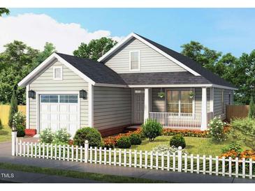 Charming single-story home boasts a manicured lawn, a white picket fence, and an attached garage at 701 East St, Smithfield, NC 27577