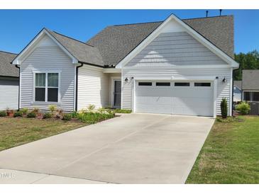 Charming one-story home featuring a two-car garage, a well-maintained lawn, and tasteful landscaping at 2432 Nassau Trce, Fuquay Varina, NC 27526