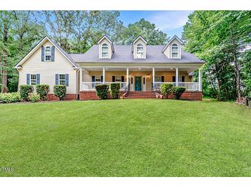 Charming home featuring a welcoming front porch, well-manicured lawn, and classic architectural details at 26 Shadymont Dr, Pittsboro, NC 27312