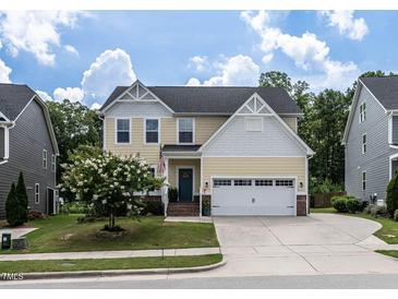 Charming two-story home featuring a well-manicured lawn, flowering tree, and a classic facade at 3441 Jordan Shires Dr, New Hill, NC 27562