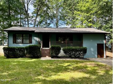 Charming single story home with green paint, brown trim, and covered porch at 424 Shawnee Dr, Louisburg, NC 27549