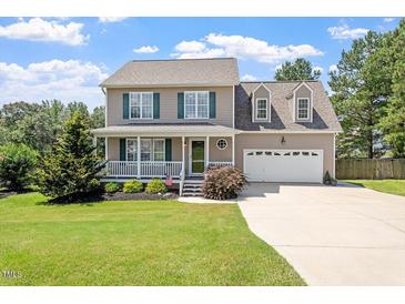 Charming two-story home featuring a cozy front porch and attached two-car garage at 44 Clarke Ct, Angier, NC 27592