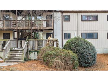 Multi-level condo building featuring wood balconies, neutral siding, and well-maintained landscaping with pine straw at 550 Pine Ridge Pl, Raleigh, NC 27609