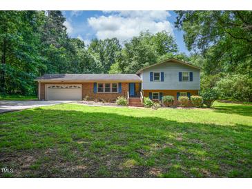 Two-story home featuring a brick and siding exterior, attached garage and green lawn at 6308 Rolling Acres Drive, Gibsonville, NC 27249