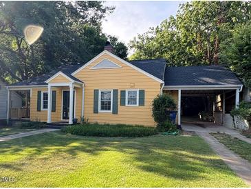 Charming yellow home with green shutters, covered parking, and a well-manicured lawn at 719 E Whitaker Mill Rd, Raleigh, NC 27608