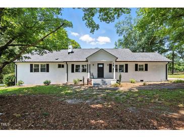 Charming brick ranch home with a new roof and black shutters surrounded by mature trees at 7722 Nc 27, Lillington, NC 27546