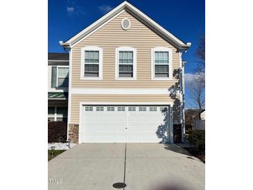 Exterior shot of a two-car garage with white door, beige siding, and white trim around windows at 8836 Thornton Garden Ln, Raleigh, NC 27616
