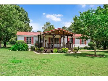 Charming single-story home featuring a covered front porch and well-manicured lawn with tasteful landscaping at 1007 Windward Hill Ct, Middlesex, NC 27557