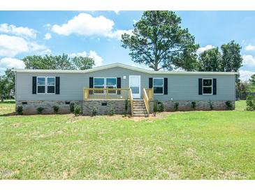 Charming one-story home featuring a freshly cut lawn, and a light gray exterior at 103 Cottonwood Ct, Kenly, NC 27542