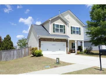 Charming two-story home with a two-car garage, stone accents, well-manicured lawn and driveway at 1940 Dunfield Dr, Fuquay Varina, NC 27526