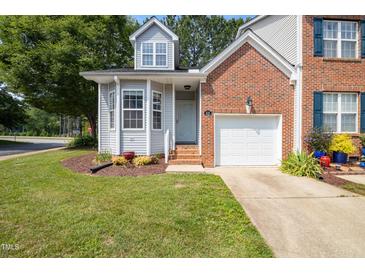 Charming two-story townhome with a brick and siding exterior, a well-manicured lawn, and an attached one-car garage at 428 Grand Pointe Dr, Garner, NC 27529