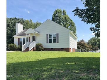 Charming one-story home with manicured lawn, brick foundation, white siding, and inviting front porch at 6 Boxley Dr, Wendell, NC 27591