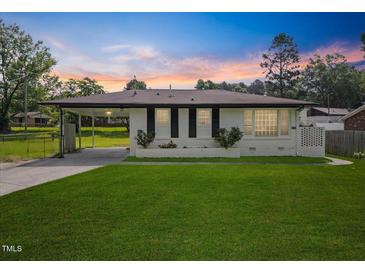 Charming one-story home featuring a well-manicured lawn and a covered carport at 1020 Benning St, Durham, NC 27703