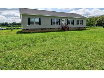 Charming one-story home featuring black shutters, a large front yard, and gray siding at 555 Hinnant Rd, Selma, NC 27576