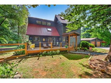 Charming two-story home featuring a metal roof, inviting front porch, and a beautifully landscaped yard at 133 Acorn Ln, Pittsboro, NC 27312