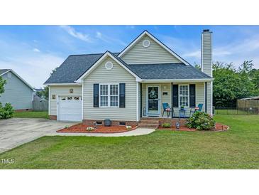Charming single Gathering home features a well-manicured lawn, tidy landscaping, and a cozy front porch at 104 Roscommon Ln, Clayton, NC 27520