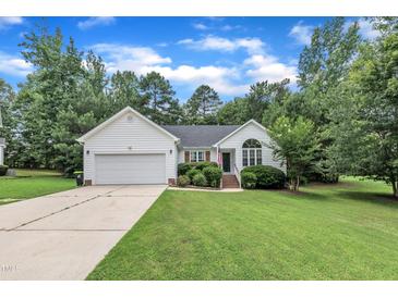 Charming home featuring a manicured lawn, attached garage, and well-maintained landscaping at 2003 Zbonack Ct, Creedmoor, NC 27522
