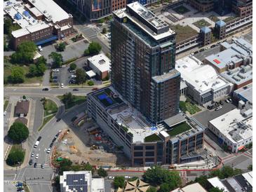 Modern high-rise building with balconies, showcasing a mix of commercial and residential spaces with a unique architectural design at 400 W Main St # 2002, Durham, NC 27701