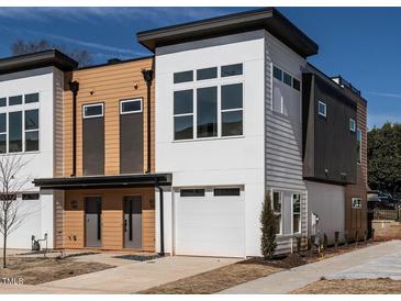 Modern townhome featuring a two-car garage, clean architectural lines and mixed material elevation at 610 Walnut Hts Dr # 102, Raleigh, NC 27610