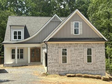 Charming exterior elevation featuring stone accents and a beautifully designed roofline at 57 Hazelwood, Pittsboro, NC 27312