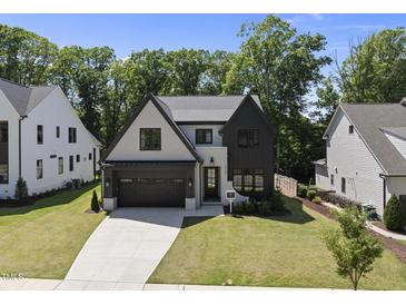 Beautiful modern farmhouse-style home with a well-manicured lawn and a two-car attached garage at 5307 Dixon Dr, Raleigh, NC 27609