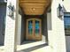 Grand entryway with a double-door entry, brick pillars, and dark trim on a new construction home at 3812 Peaceful Creek Trl, Zebulon, NC 27597