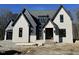Striking two-story new construction home with gray brick and complementary trim details under a clear blue sky at 3812 Peaceful Creek Trl, Zebulon, NC 27597