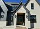 Close up of a beautiful new construction home with an elegant, light-colored brick and dark trim around the entryway at 3812 Peaceful Creek Trl, Zebulon, NC 27597