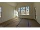 A view of an unfinished living room featuring large windows and lots of natural light at 3812 Peaceful Creek Trl, Zebulon, NC 27597