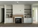 A view of an unfinished living room with a fireplace flanked by built-in shelving at 3812 Peaceful Creek Trl, Zebulon, NC 27597