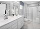 Well-lit bathroom featuring double sinks, sleek cabinetry, and a glass-enclosed shower at 164 Clove Hitch Ln, Fuquay Varina, NC 27526