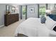 Serene bedroom with a plush bed, soft lighting, a dresser, and views from two windows at 164 Clove Hitch Ln, Fuquay Varina, NC 27526