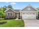 Charming home with a two-car garage, stone accents, manicured lawn and a bright yellow front door at 164 Clove Hitch Ln, Fuquay Varina, NC 27526