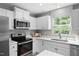 Bright kitchen featuring white cabinets, stainless steel appliances, and a window over the sink at 164 Clove Hitch Ln, Fuquay Varina, NC 27526