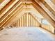 Spacious unfinished attic featuring wooden beams and a window, ready to be customized into a unique living space at 508 Northwood Dr, Raleigh, NC 27609