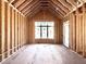 Unfinished bedroom with vaulted ceiling, framing, and a large window for natural light at 508 Northwood Dr, Raleigh, NC 27609