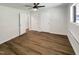 Bright bedroom featuring a ceiling fan, hardwood floors, white walls, and three white doors at 130 S Estes Dr # B7, Chapel Hill, NC 27514