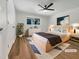 Bright bedroom featuring a large window, hardwood floors, a ceiling fan, neutral decor, and modern furnishings at 130 S Estes Dr # B7, Chapel Hill, NC 27514