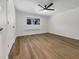 Bright bedroom featuring a large window, hardwood floors, a ceiling fan, and white walls at 130 S Estes Dr # B7, Chapel Hill, NC 27514