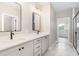 A luxurious bathroom features double vanities with black hardware and a view into another room at 7327 Shawan Rd, Wendell, NC 27591