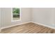 A bright bedroom features a large window providing natural light and wood-look flooring at 7327 Shawan Rd, Wendell, NC 27591